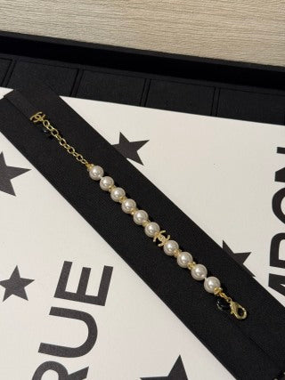 Chanel light gold bracelet with white pearls and full pavé-set stones.