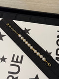 Chanel light gold bracelet with white pearls and full pavé-set stones.