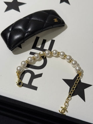 Chanel light gold bracelet with white pearls and full pavé-set stones.